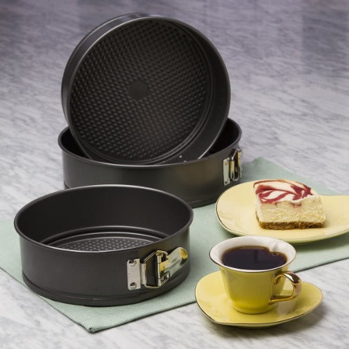 Ecolution Spring form Pans on display next to coffee and a piece of cake
